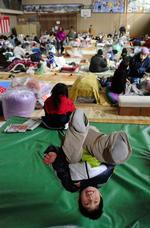 En dreng leger i et evakueringscenter i Kamaishi. 