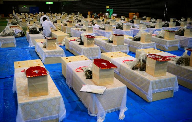 En mand undersøger et offer for tsunamien i et gymnasium i Rifucho, der er omdannet til lighus. 