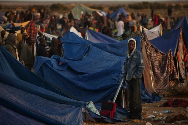 Her ses afrikanske immigrantarbejdere, der er flygtet fra de seneste ugers kampe i Libyen. De har tilbragt natten i en flygtningelejr i Tunesien. 