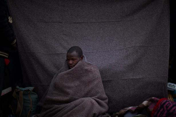 En mand fra Ghana, der plejer at arbejde i Libyen er flygtet ud af landet og sidder her uden for et telt i en flygtningelejr i Tunesien. 