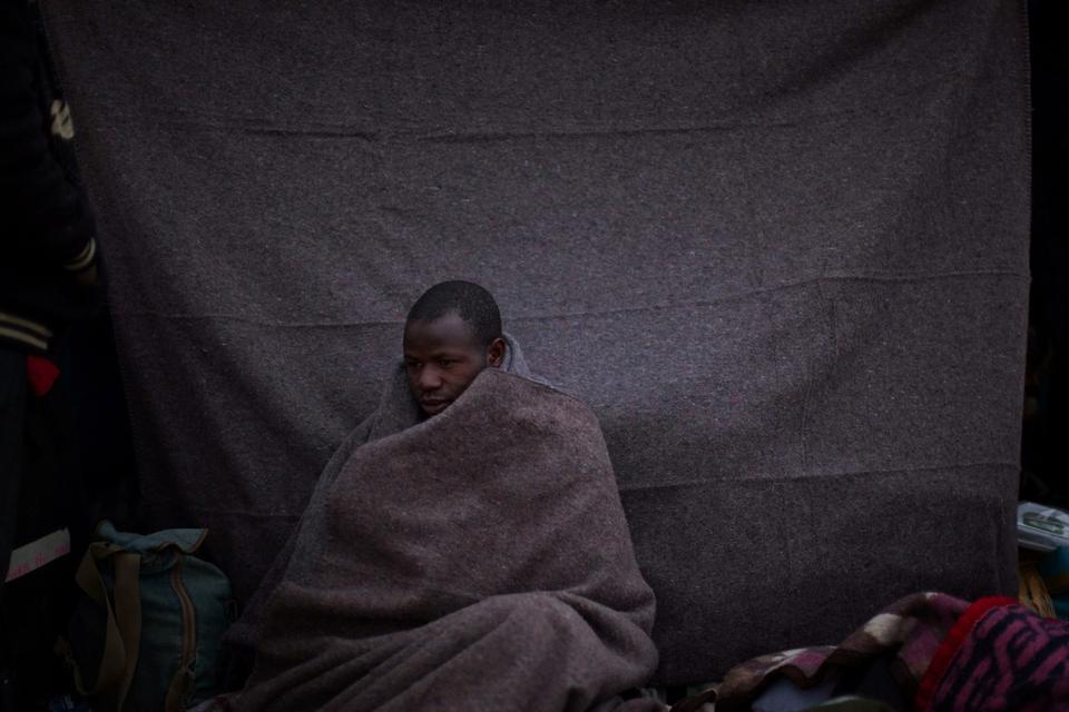 En mand fra Ghana, der plejer at arbejde i Libyen er flygtet ud af landet og sidder her uden for et telt i en flygtningelejr i Tunesien. 