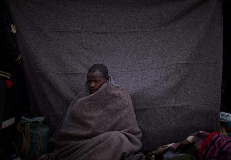 En mand fra Ghana, der plejer at arbejde i Libyen er flygtet ud af landet og sidder her uden for et telt i en flygtningelejr i Tunesien. 