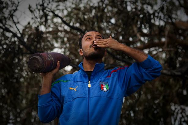 En libysk oprører iført en italiensk fodbold-trøje fejrer, at oprørerne nu har fået støtte fra Vesten. 