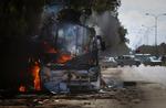 En bus i brand i udkanten af oprørsbyen Benghazi i dag. 