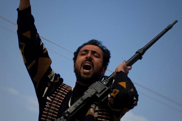 En libysk oprører jubler i udkanten af byen Benghazi i det østlige Libyen. 