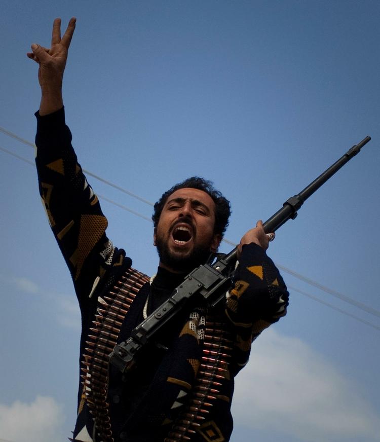 En libysk oprører jubler i udkanten af byen Benghazi i det østlige Libyen. 
