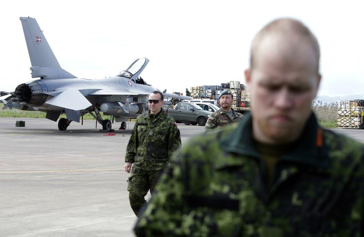Krig. Danske soldater foran et F16-jagerfly på Sigonella-luftbasen i går. De danske jagerfly har gennemført to aktioner i Libyen, og er netop lettet på det tredje togt. 