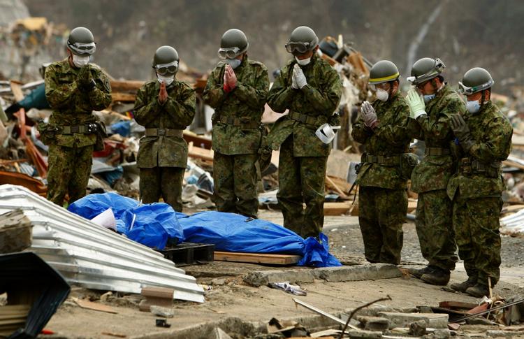Respekt. Japanske soldater beder for et af ofrene for tsunamien i byen Onagawa i Miyagi-distriktet. 
