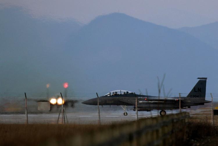 Kampklar. Et F15-kampfly gør klar til at lette fra Aviano luftbasen i Italien, mens et andet allerede drøner ud ad startbanen. Billedet er taget i går. 
