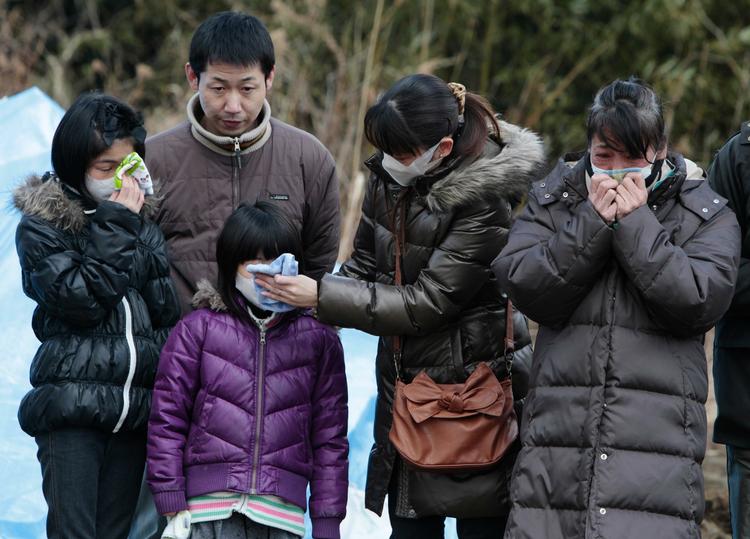 Sorg. Efterladte overværer en begravelse af ofre for naturkatastrofen i byen Higashimatsushima. 