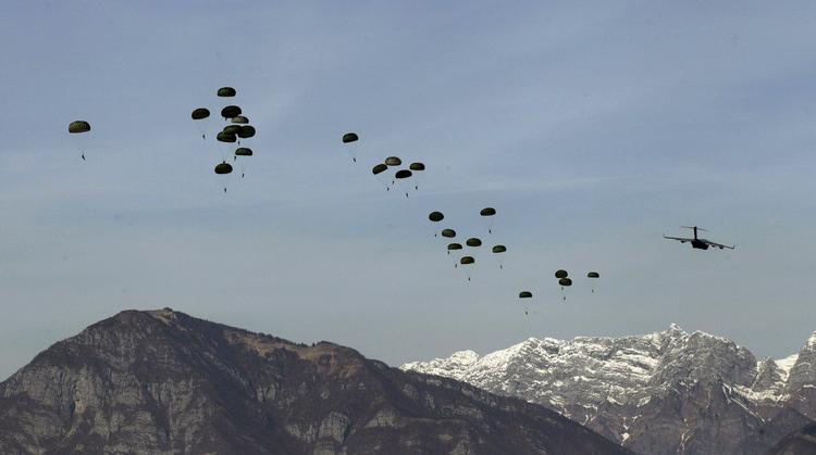 U.S. troops parachute out of a C-17 plane flying over Maniago, near the NATO airbase of Aviano, Italy, during an exercise yesterday. 