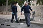 ANGREB. Israelske ingeniørsoldater fjerner resterne af en palæstinensisk raket, der ramte gade i byen Beersheba. 
