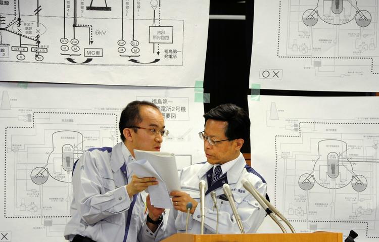 Sikkhedspersonale. Talsmand for den japanske atomare sikkerhedsorganisation, Hidehiko Nishiyama (th.) diskuterer en detalje med sin medhjælper på gårsdagens pressemøde. 