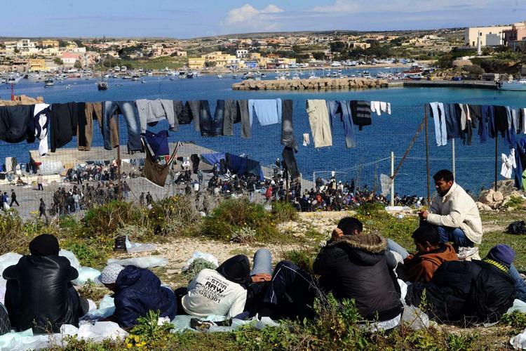 VENTETID. Indvandrere venter ved havnen i Lampedusa. 