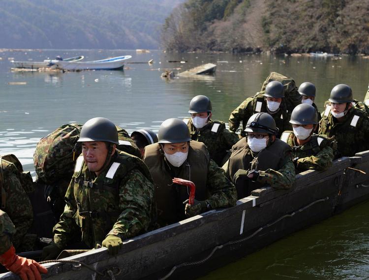 Eftersøgning. Japanske soldater i dag ved den hærgede kyst ud for Ishinomaki i den nordlige del af landet . 