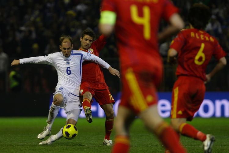 Bosnien-Hercegovinas Elvir Rahimic (tv) får bolden foran Rumæniens Adrian Mutu i det, der blev den lille Balkan-stats foreløbig sidste landskamp. 