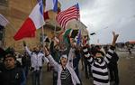 Hyldest. Unge libyere vifter med flag fra koalitionens lande efter fredagsbønnen i Benghazi. 