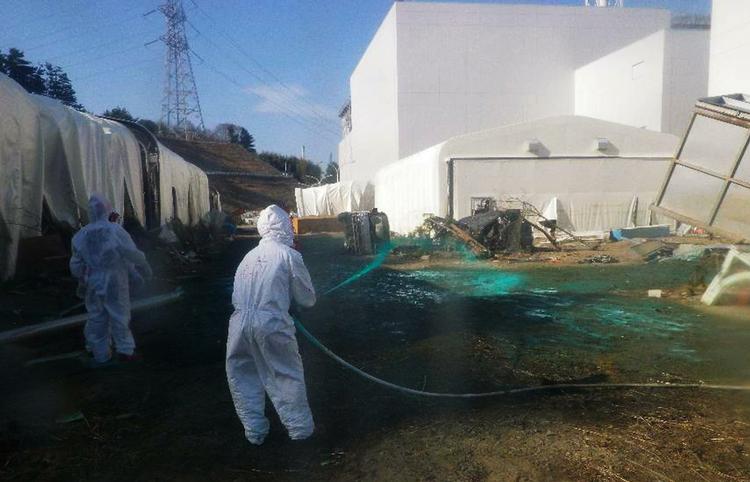 Eksperiment. Arbejdere på Fukushima-værket forsøger sig med at sprøjte en blanding af syntetisk harpiks ud over området ved Fukushima-værket. Den klistrede blanding skal stoppe radioaktive partikler fra at flyve med vinden og ud i landskabet. 