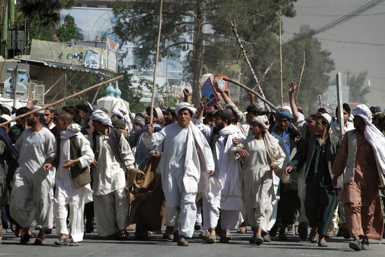 Vrede. Aghanske demonstranter i byen Kandahar bærer en såret demonstramt gennem gaderne. Demonstranterne er vrede over den amerikanske præst Terry Jones, der brændte en udgave af Koranen af 20. marts. 