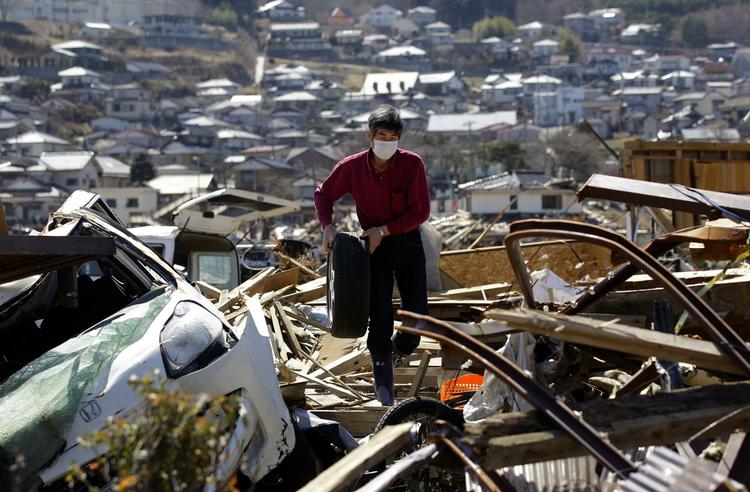 Overlevende. Keichi Kudo finder et bildæk i ruinerne efter jordskælvet i Japan. 28.000 meldes dræbt eller savnet som følge af skælvet og den efterfølgende tsunami. 
