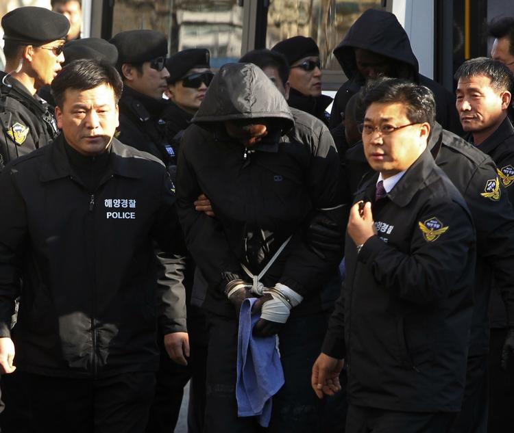 PÅGREBET. Et af de lande, der ikke lader somaliske sørøvere gå, er Sydkorea. Her føres tilfangetagne pirater i land i Sydkorea, hvor de skal retsforfølges for kapring af et sydkoreansk handelsfartøj. Arkivfoto. 