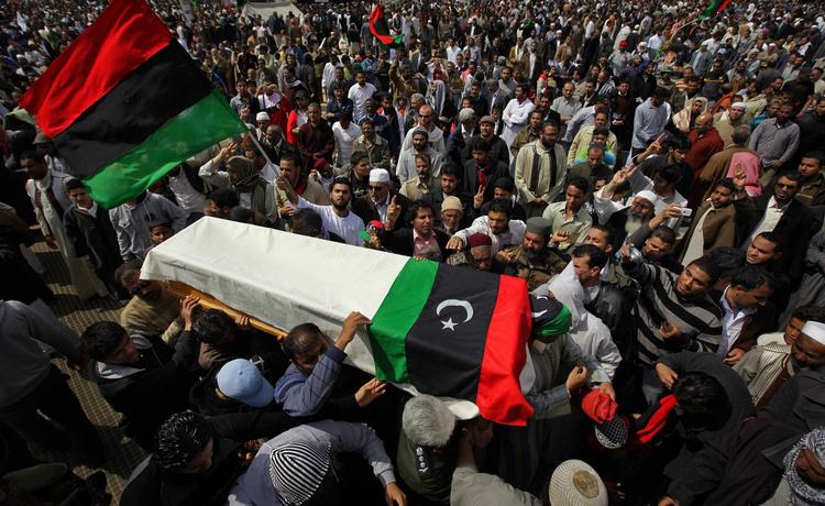Blacklisting. USA strammer grebet om Gaddafis regering. Yderligere fem ministres aktiver i USA er blevet frosset inde for presse dem til at vende ryggen til Gaddafi. Billedet her er fra en begravelsesceremoni i dag i Benghazi. Indbyggerne samledes og sørgede over tabet af flere oprørere under et luftangreb i går. 