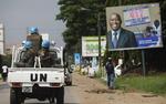 Folkemord?  Flere beretninger fra eksilivorianere vidner om, at styrker tro mod hver sin præsident kandidat har mishandlet og drabt civile. På billedet paserer FN-tropper en valgplakat for Laurent Gbagbo. 