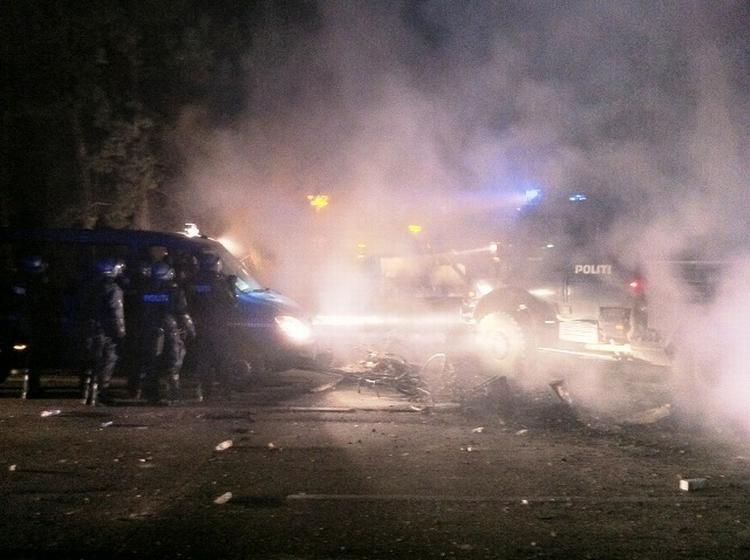 VEJRYDNING. Mens betjente står beskyttet mod stenkast bag deres gruppevogn satte Københavns Politi en specialbygget, kraftig rydningsvogn ind for at få fjernet de brændende barrikader fra gaderne omkring fristaden. 