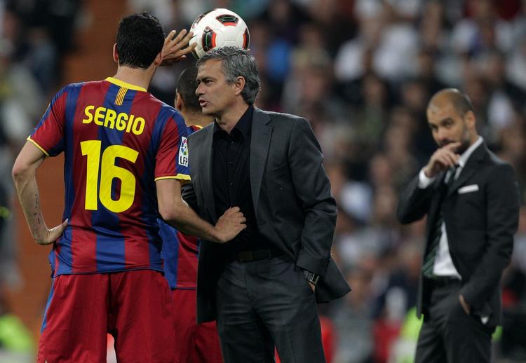 defensivt. Real Madrid-træner José Mourinho (midt) driver sit psykologiske spil under kampen mod Barcelona, hvor han forstyrrer Barcelonas Sergio Busquets ved sidelinjen under et indkast. 