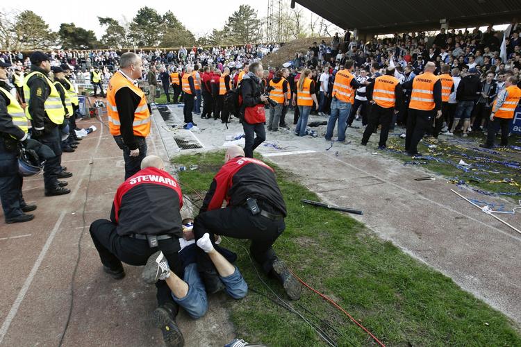 Begejstringsdæmper. Stadionpersonale bringer en FCK-tilhængers sejrseufori ublidt til ende. 