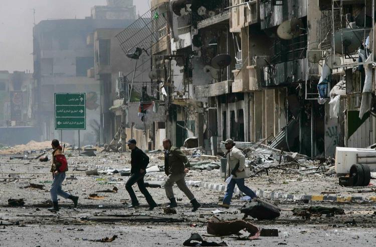 Kampzone. Oprørere krydser en gade i den belejrede by Misrata i går. 