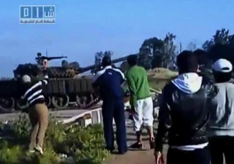 Kasteskyts. På dette billede, der er taget fra en amatørvideo bragt af Sham News Network, er en mand ved at kaste en ting mod en tank i byen Daraa. 