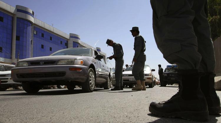 FANGEFLUGT. Afghanske betjente ved en kontrolpost, hvor bilisters papirer i jagten på den undvegne indsatte fra fængslet i Kandahar. 