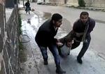 Civile. Demonstranter slæber en kammerat væk, som er blevet skudt midt på gaden. Billedet er fra en amatørvideo fra Daraa. 