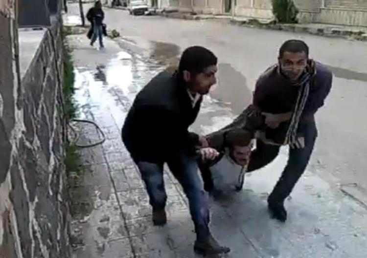 Civile. Demonstranter slæber en kammerat væk, som er blevet skudt midt på gaden. Billedet er fra en amatørvideo fra Daraa. 