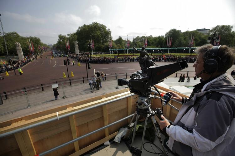 BRYLLUPSDÆKNING. Kameramand tjekker udstyret ud for Buckingham Palace. I alt 140 kameraer er opstillet langs brudeparrets rute fra kirken til kongefamiliens slot i London. 