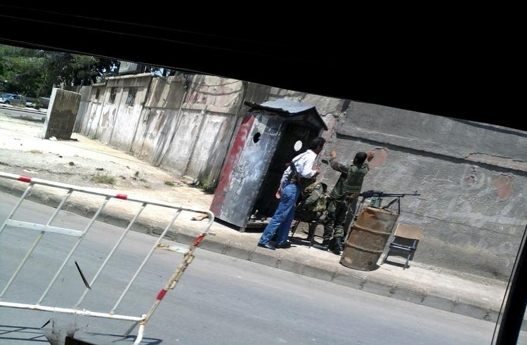 Ikke mange fotografier slipper ud af Syrien, men nyhedsbureauet AP har fået fat i dette billede, der er taget med en mobiltelefon ud af et bilvindue og viser et checkpoint i Damaskus. 