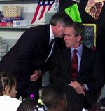 11. september 2001. George W. Bushs stabschef, Andy Card, hvisker nyheden om angrebene på World Trade Center og Pentagon i ørene på en chokeret præsident. 