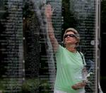 Kathy Maycen rækker ud for at røre ved sin datters navn på det mindesmærke for ofrene, der er rejst i Palm Beach, Florida. 