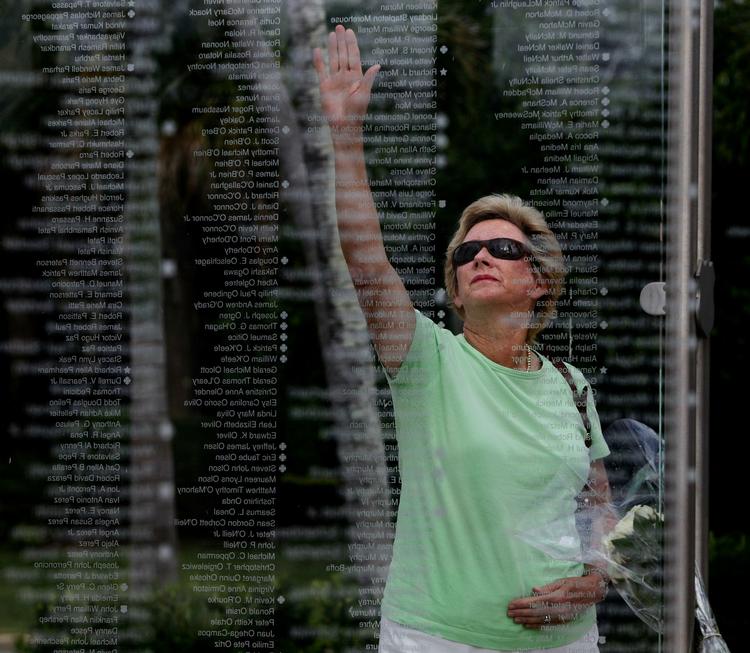 Kathy Maycen rækker ud for at røre ved sin datters navn på det mindesmærke for ofrene, der er rejst i Palm Beach, Florida. 