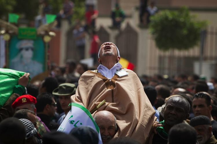 Sorg. Selv om Moamar Gaddafi beskyldes for krigsforbrydelser, så har han også tilængere. Billedet viser angiveligt en sørgende libyer ved begravelsen af diktatorens søn, der døde i et bombeangreb. Optrinnet blev fotograferet ved en pressetur med regeringsguider i tirsdags. 