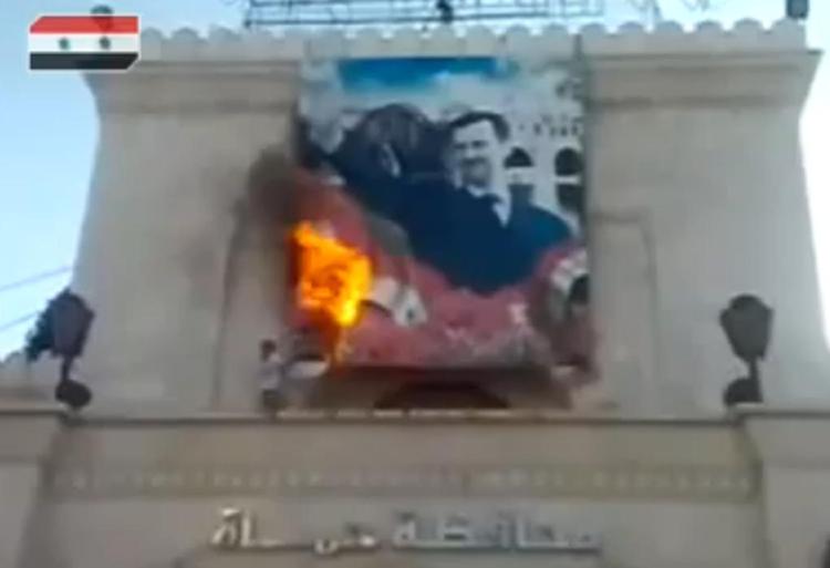 Vrede. Det er stort set umuligt at billeddokumentere begivenhederne fra det hermetisk tillukkede Syrien. Her er det en skærmdump fra en af de lavopløsningsvideoer, som florerer på nettet. Billedet synes at vise en demonstrant, som sætter ild til en plakat af landets præsident Assad. 
