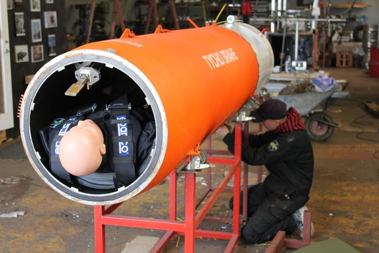 Nørderi. Kristian von Bengtson arbejder på sit rumskib 'Tycho Brahe', som snart sidder oven på raketten 'Heat-1x' og forhåbentlig sammen forsvinder fra havets overflade i en hulens fart. 