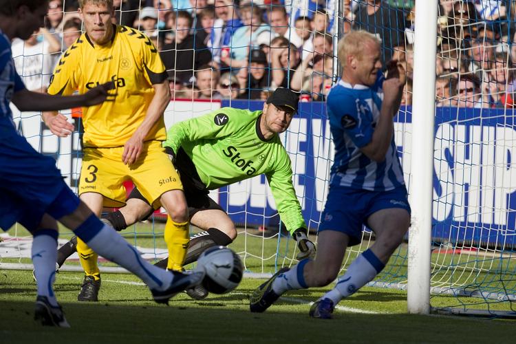 livligt. OB's Daniel Høegh scorer kampens første mål, mens Hans-Henrik Andreasen forsøger at flytte sig for skuddet. 