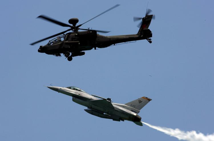 Angrebsvåben. En Apache-helikopter fotograferet ved et flyshow i Singapore sidste år. Briterne sætter fire af dem ind i Libyen, hvor blandt andet Danmark bidrager med flere den slags F16-kampfly, som også ses på billedet. 