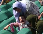 En kvinde trøster sin datter under en begravelse af 338 ofre for massakren i 1995. 