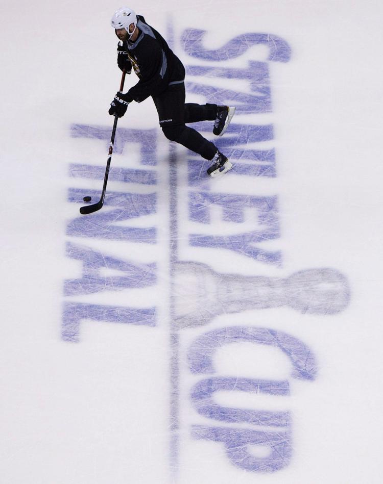 Glat. En Boston Bruins-spiller skøjter over logoet på den bane i Vancouver, hvor den første finale om Stanley Cup-trofæet finder sted. 