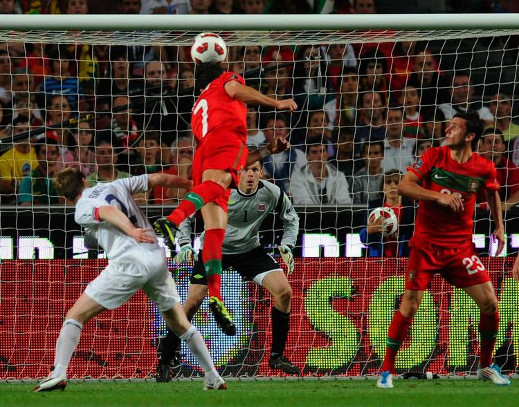 Duel. Portugals Cristiano Ronaldo kommer højt til vejrs og for en gangs skyld fri af sin direkte oppasser Rune Høgli (tv). Norges målmand Rune Jarstein er på tæerne. 
