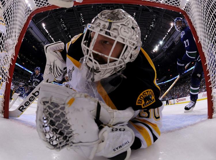 Boston Bruins målmand Tim Thomas har hovedet inde i eget mål. 