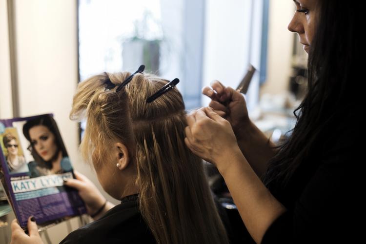 Lange lokker. Ekstra tykt og langt hår i form af hårextensions er blevet en udbredt trend i Danmark, men behandlingen er langt fra ufarlig. Her er det påsætning af hår i en frisørsalon. 
